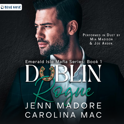 Dublin Rogue by Jenn Madore and Carolina Mac audiobook cover with a dark cement textured background and a bearded, dark-haired man in a suit looking screen left. His collar is open and he's not wearing a tie. Performed in Duet by Mia Madison and Joe Arden. Produced by Blue Nose AUDIO.