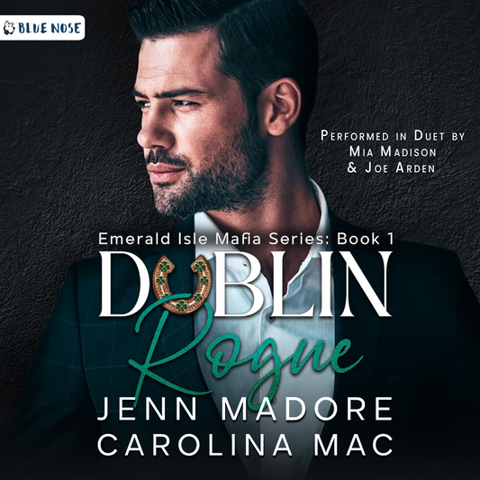 Dublin Rogue by Jenn Madore and Carolina Mac audiobook cover with a dark cement textured background and a bearded, dark-haired man in a suit looking screen left. His collar is open and he's not wearing a tie. Performed in Duet by Mia Madison and Joe Arden. Produced by Blue Nose AUDIO.